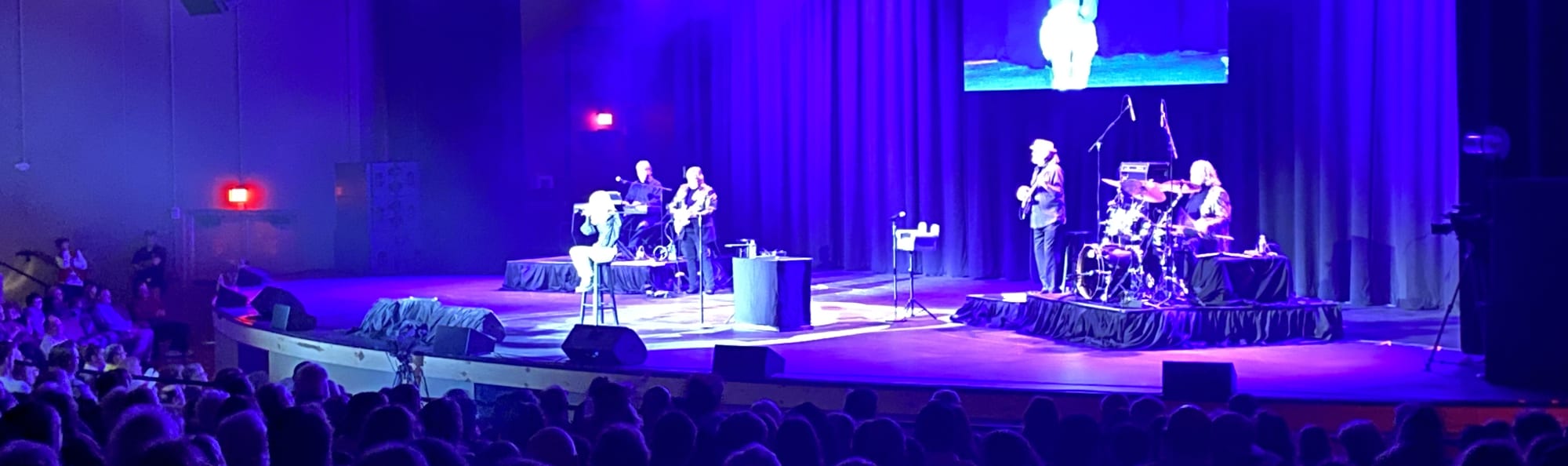 signer on stage in chair washed out by the lights Lancaster